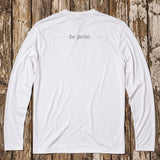 White long-sleeve shirt with 'be pono' text on a wooden background
