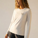 Woman wearing a white long-sleeve shirt with a Kailua Hi logo on a plain background