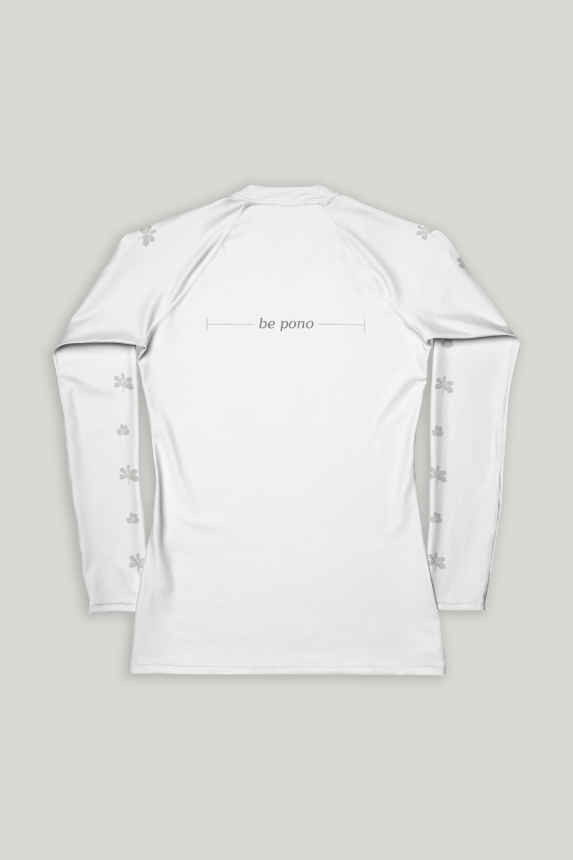 White long-sleeve shirt with grey "be pono" text on the back and flowers on the sleeves on a gray background