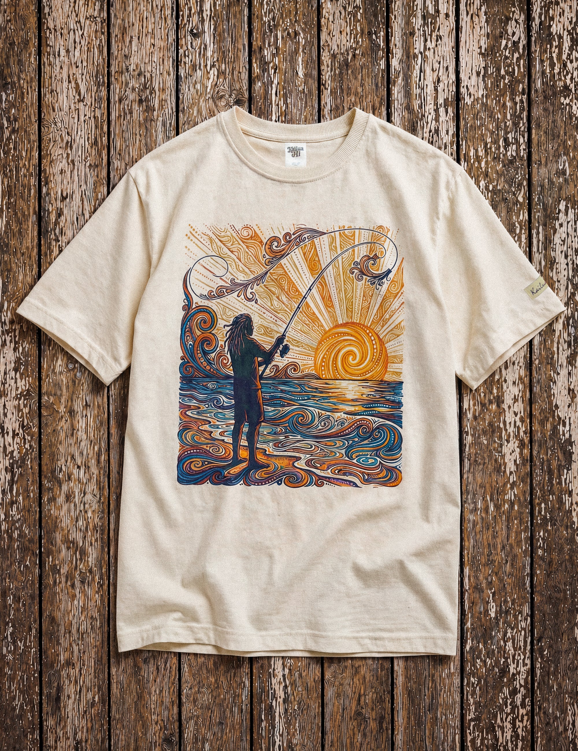 a pearl colored shirt with a colorful graphic of a person fishing laying on a wood floor
