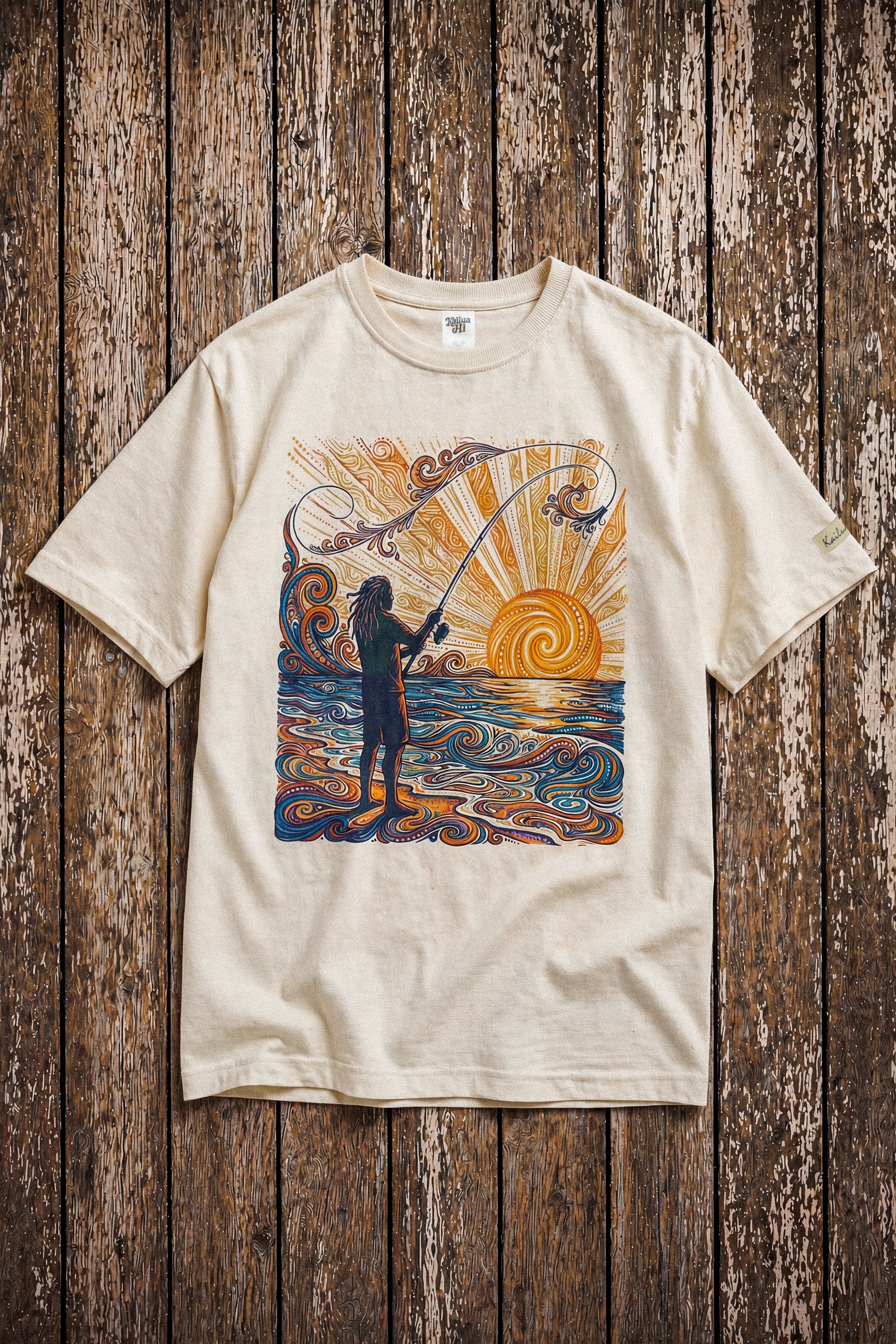 a pearl colored shirt with a colorful graphic of a person fishing laying on a wood floor