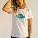 Woman wearing a white t-shirt with a blue fish graphic on a plain background