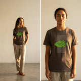 woman wearing a brown t-shirt with a green fish design on the front