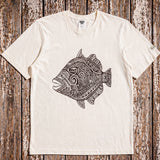 a pearl colored t-shirt with a fish graphic laying on a wood floor
