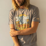Man wearing a gray t-shirt with a kailua hi logo graphic design on a plain background