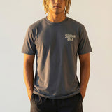 Man wearing a dark gray kailua hi vintage tee logo shirt and black shorts against a plain background