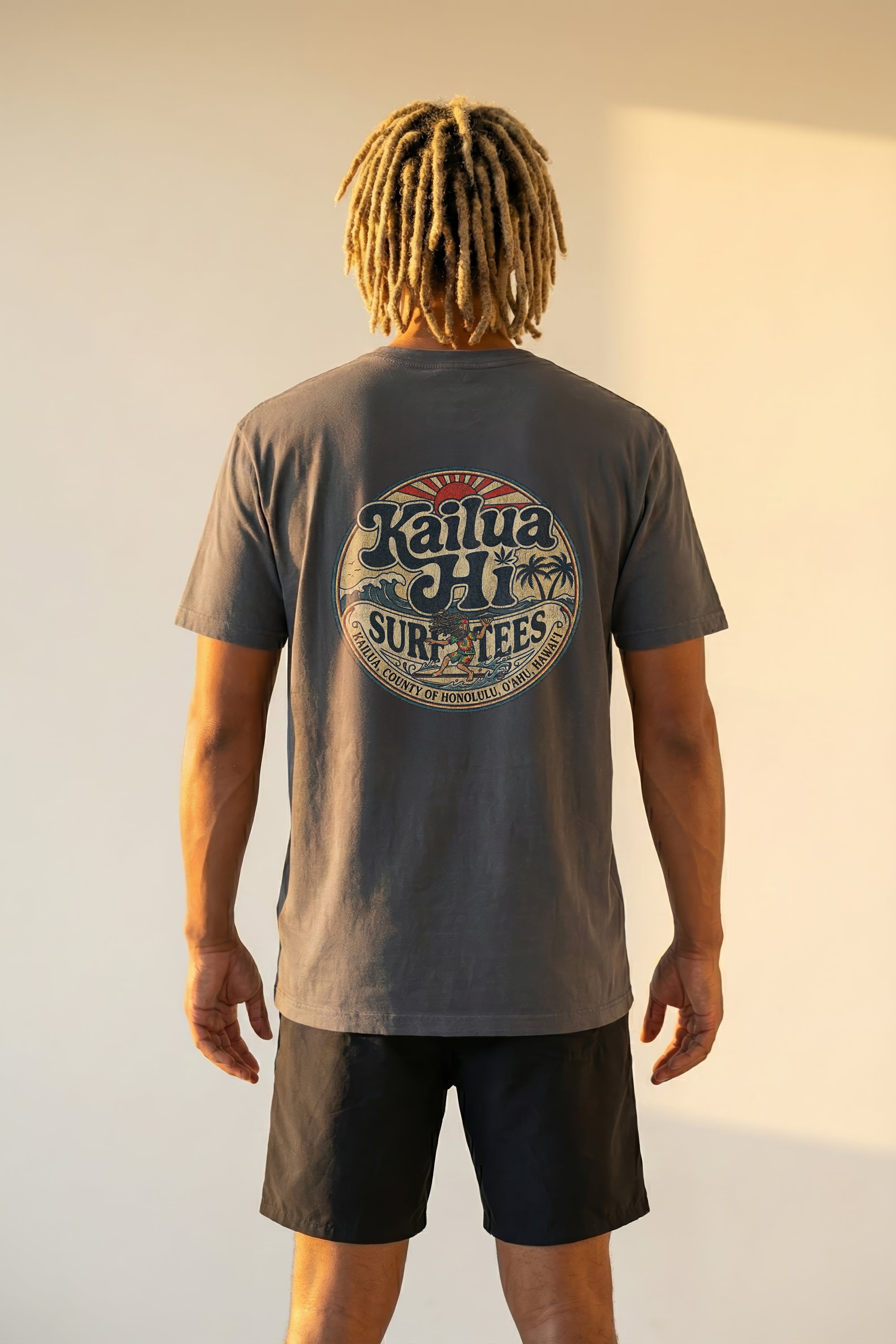 Person wearing a gray t-shirt with 'Kailua Hi Surf Tees' logo on the back, standing against a plain background.