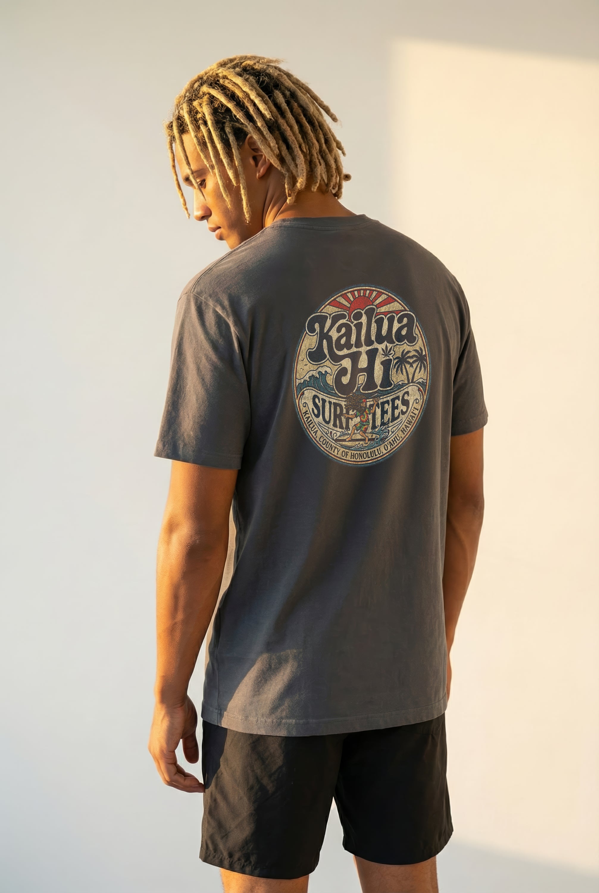 Person wearing a kailua hi vintage logo gray t-shirt with a logo on the back, standing against a plain background
