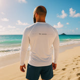 man in white long-sleeve rash guard with “be pono” back print walking along the Kailua shoreline