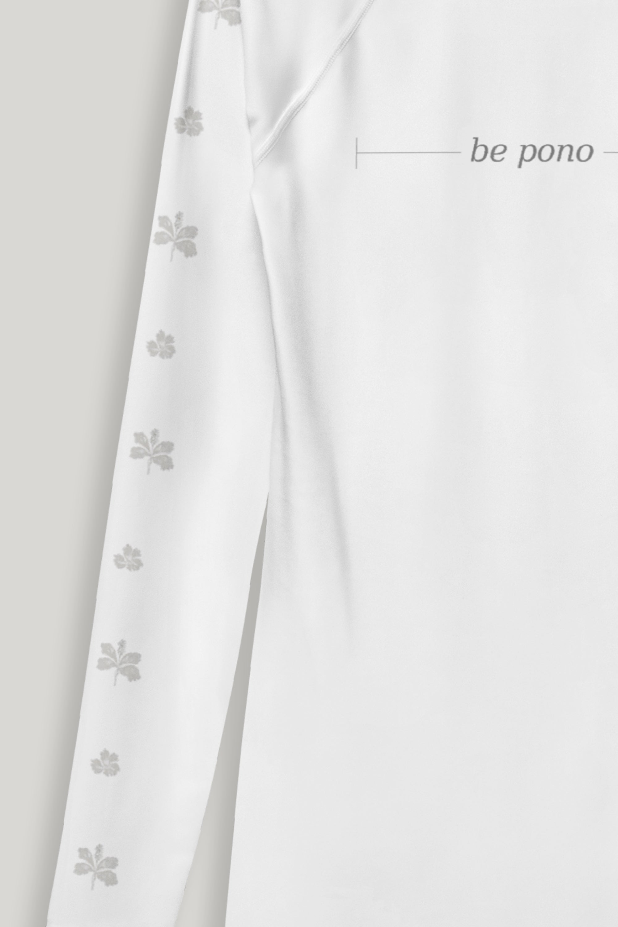 White fabric with a flower pattern on the sleeves on a light gray background, featuring the grey text 'be pono'.