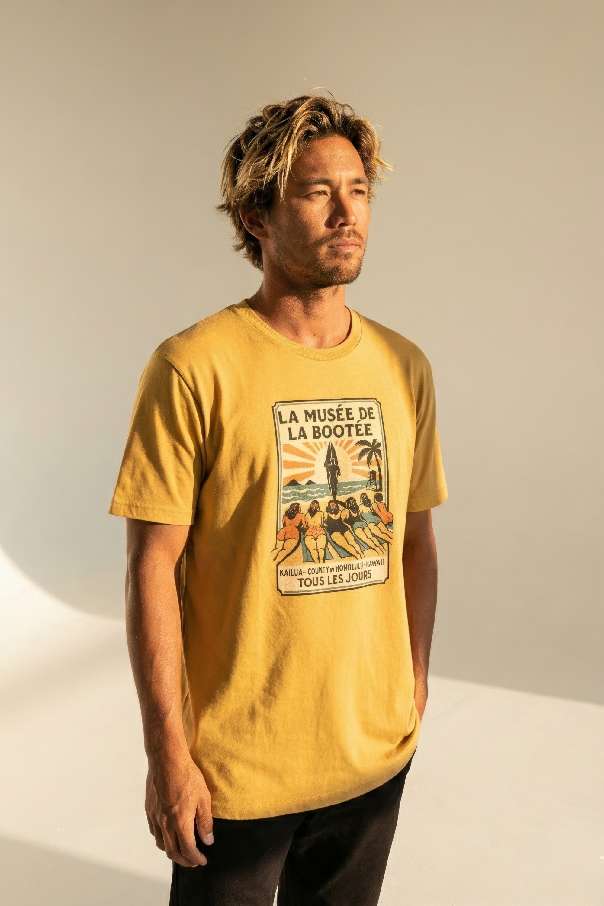 Man wearing a yellow t-shirt with a graphic design on a neutral background