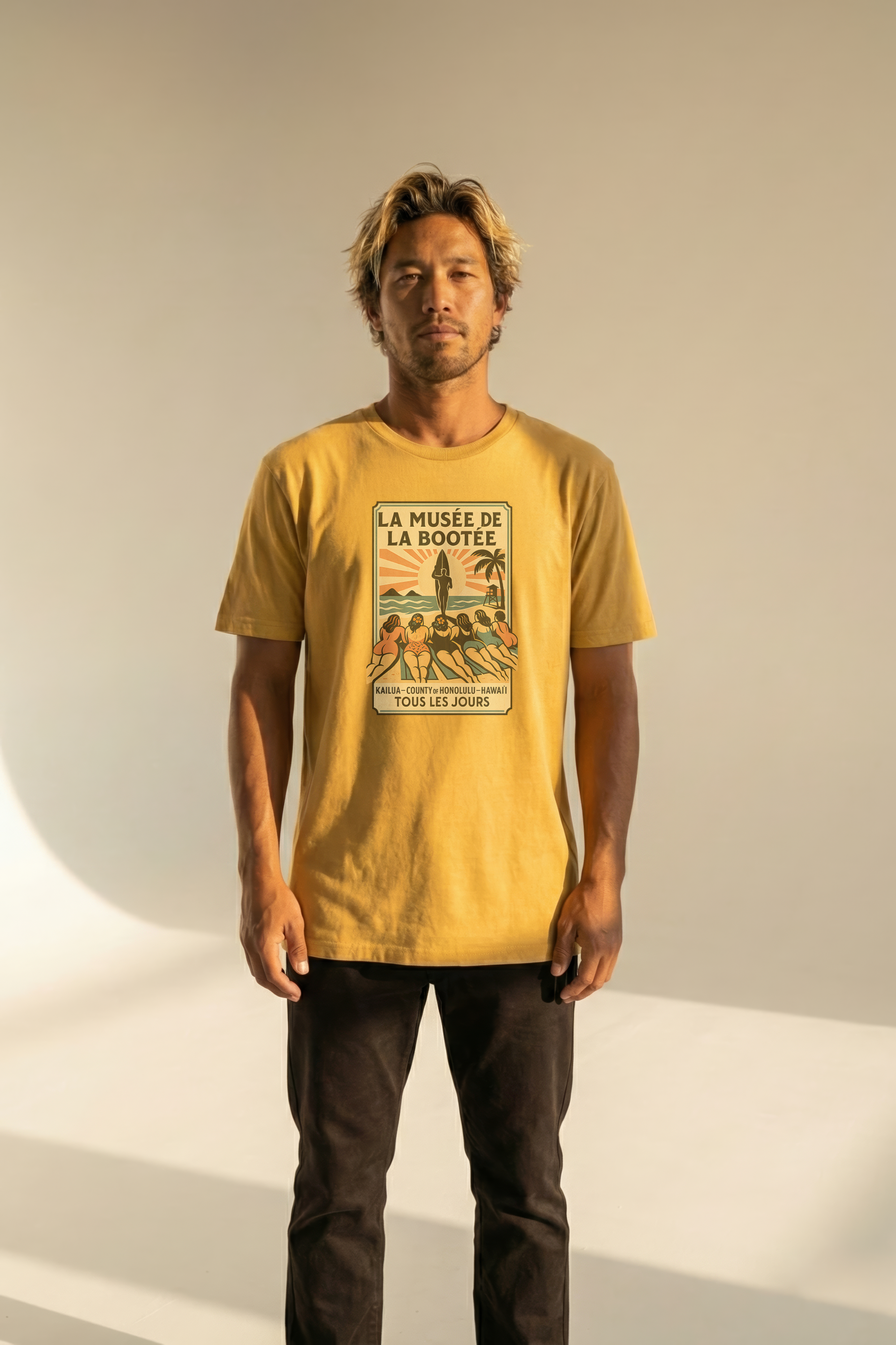 Man wearing a yellow t-shirt with a graphic design on a plain background