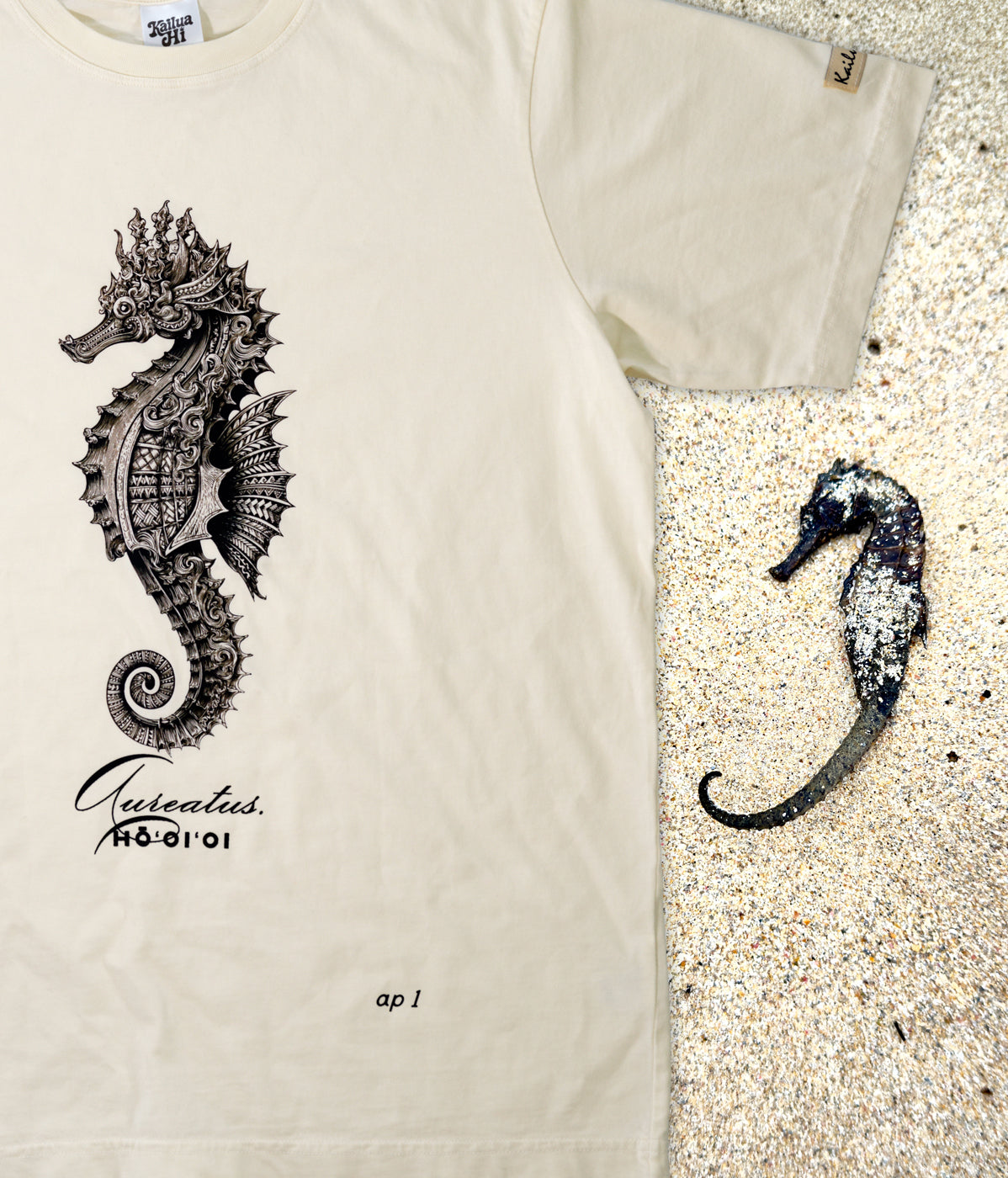 Beige t-shirt with a detailed seahorse design on a sandy background