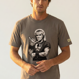 Man wearing a t-shirt with a graphic design of a muscular figure giving the shaka hand sign on a plain background