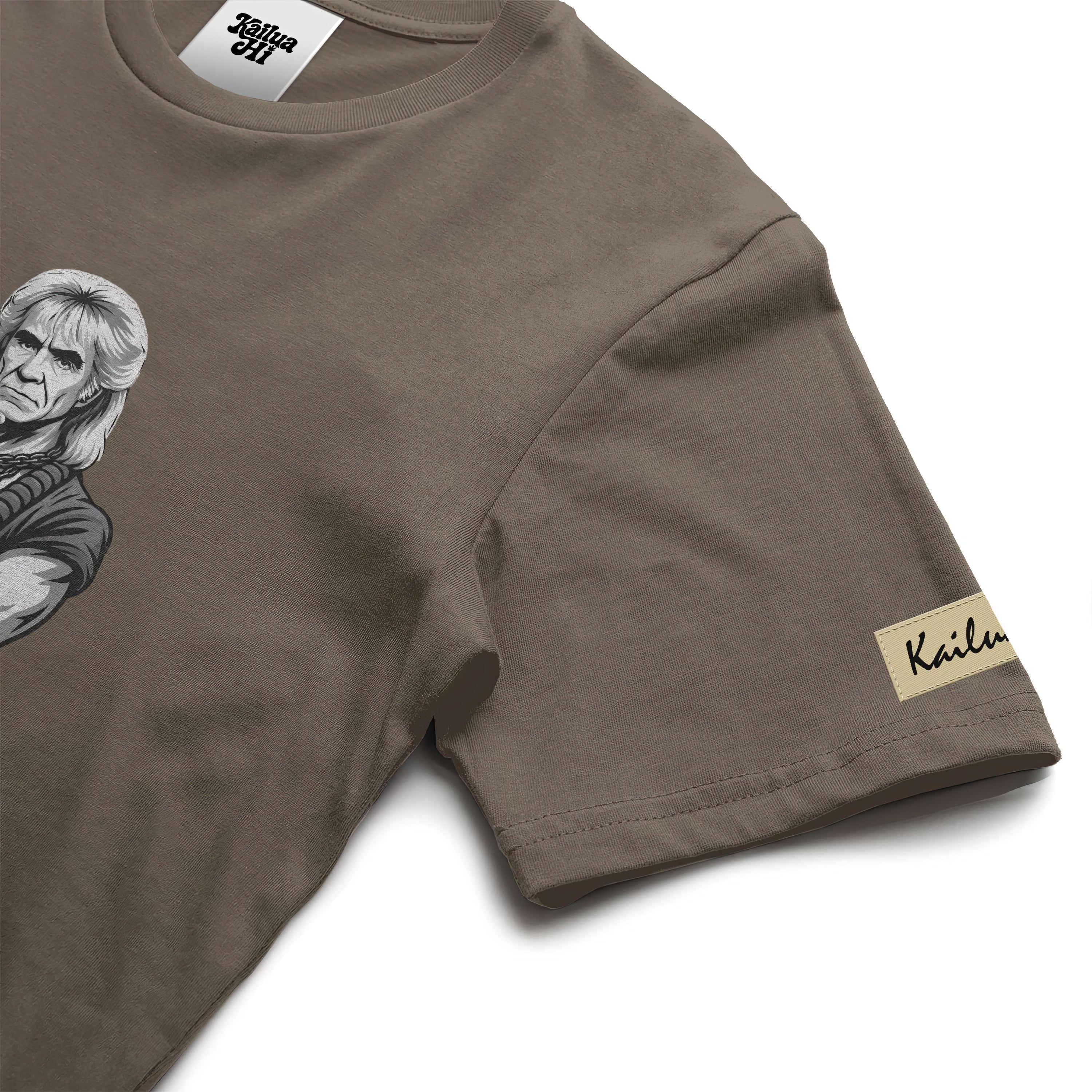 Brown t-shirt with shaka khan graphic design and kailua hi brand logo on a white background