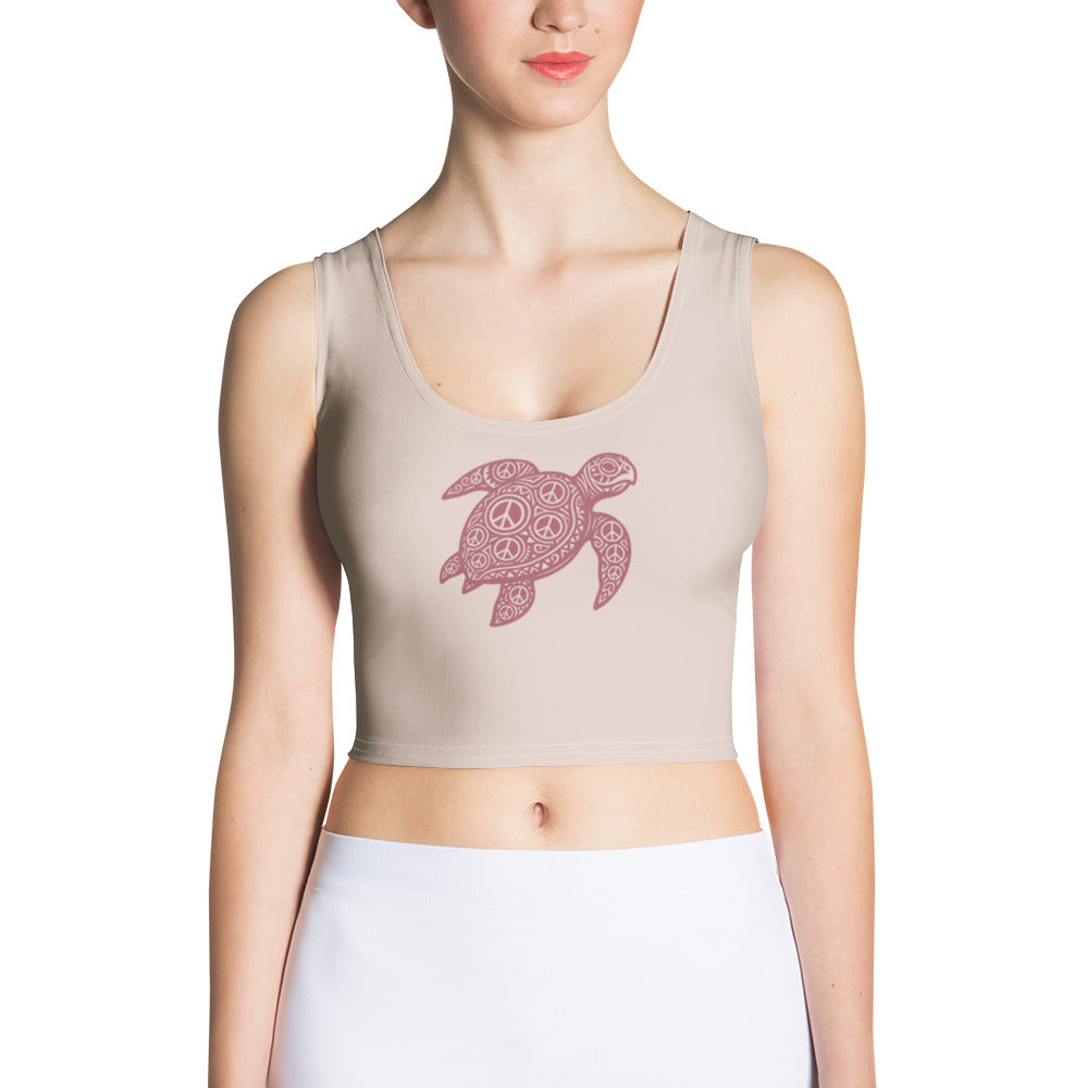 front view of light-rose, body-hugging crop top with centered burgundy honu turtle motif