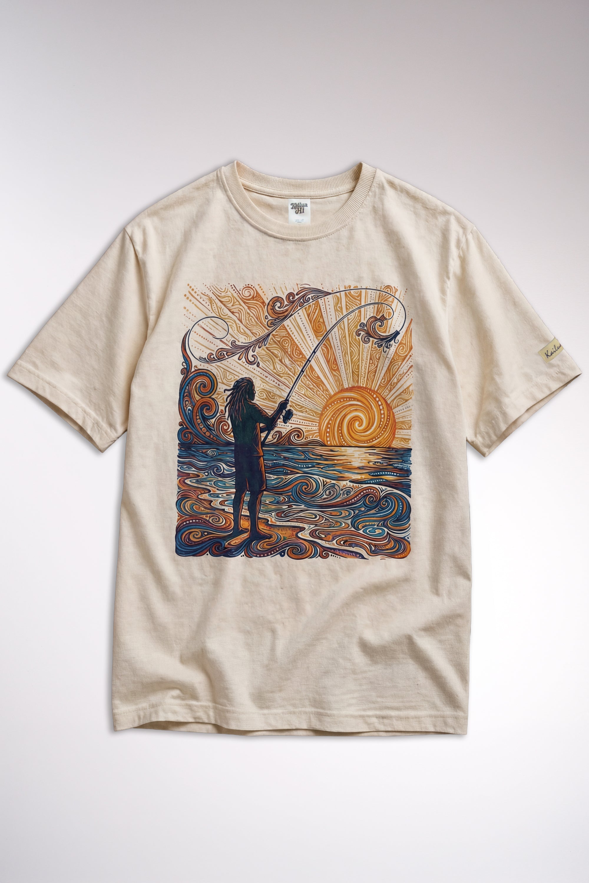 kailua hi surf tees catching rays women's luxe tee in pearl – studio flat lay product shot showing the full front graphic. features a detailed woodcut style illustration of a fisherman silhouette casting a rod into swirling orange and yellow sunset ocean waves. includes a relaxed crew neckline, interior kailua hi woven neck label, and custom sleeve tag against a neutral background