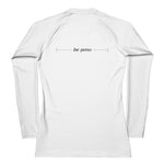 back view flat lay of white women’s rash guard showing centered “be pono” line graphic between the shoulders