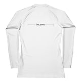 back view flat lay of white women’s rash guard showing centered “be pono” line graphic between the shoulders