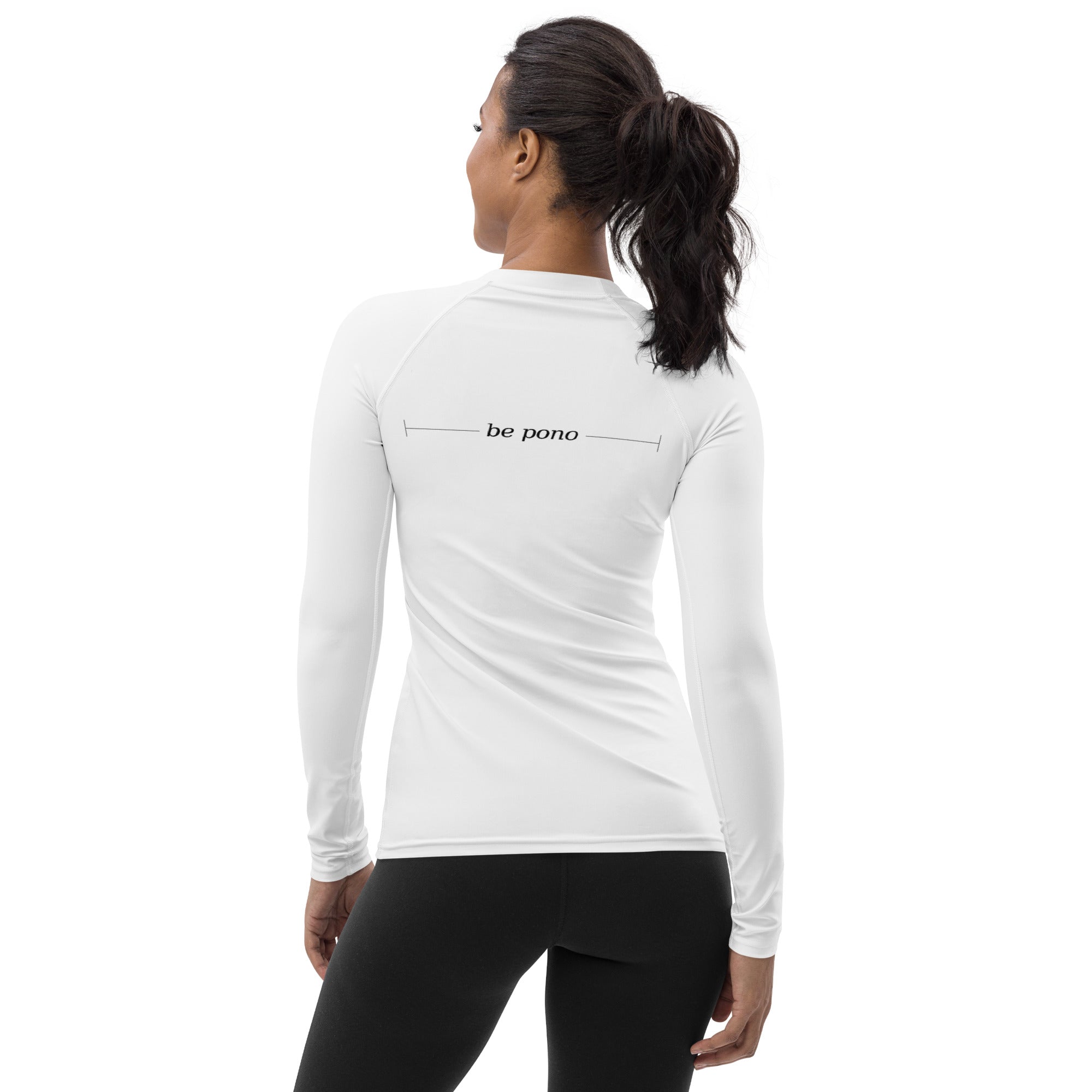 three-quarter back view of white women’s rash guard with “be pono” graphic across upper back, slim athletic fit